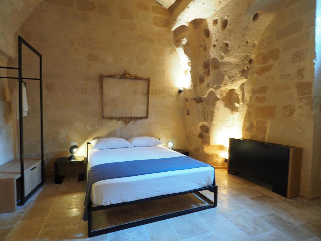 um quarto com uma cama e uma televisão num quarto em Dimore dei Mercanti em Matera