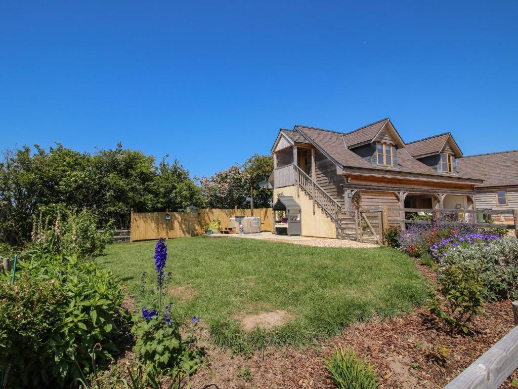 una casa grande con un patio con flores en Stable Cottage, en Bishop's Castle