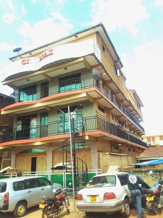 un edificio con coches estacionados frente a él en City Max hotel Kabaale en Kabale