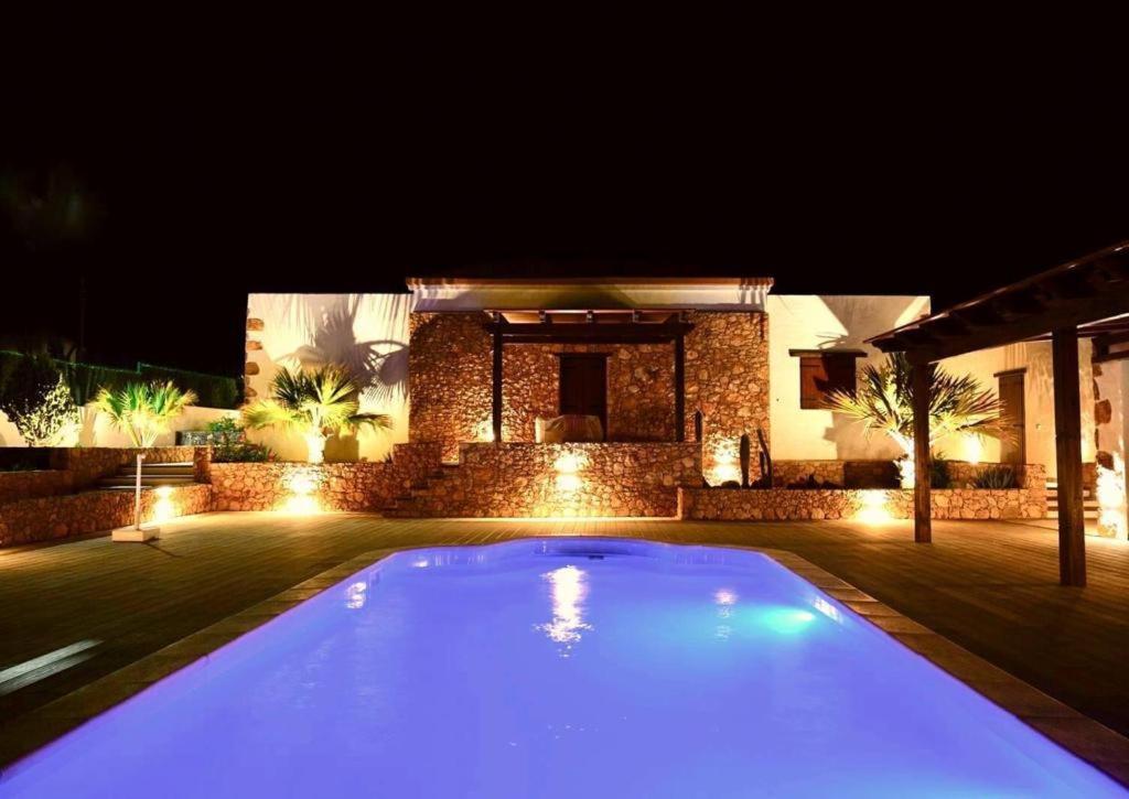 una piscina frente a una casa por la noche en Pueblo Canario en Los Estancos
