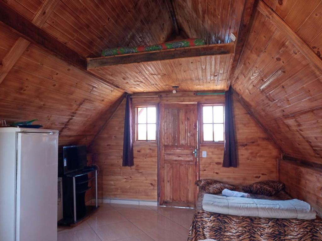 聖托梅－達斯萊特拉斯的住宿－Chalé Nascer do Sol，小木屋内的房间,配有一张床和一台冰箱