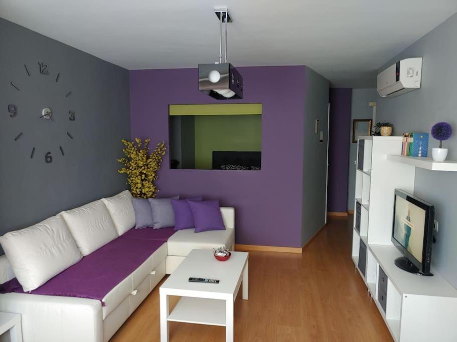 sala de estar con sofá blanco y pared morada en Casa Chema I - Apartamento/Parking/Piscina/Playa, en Cala del Moral