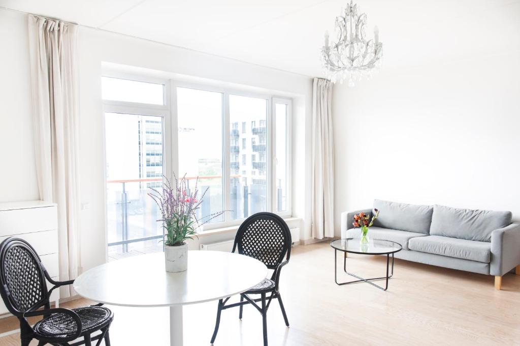 a living room with a table and chairs and a couch at Skanstes Apartment Free Parking in Riga