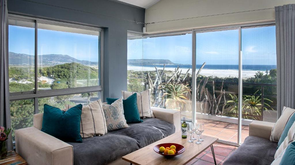 a living room with a couch and a large window at Noordhoek Bliss Beach House in Cape Town