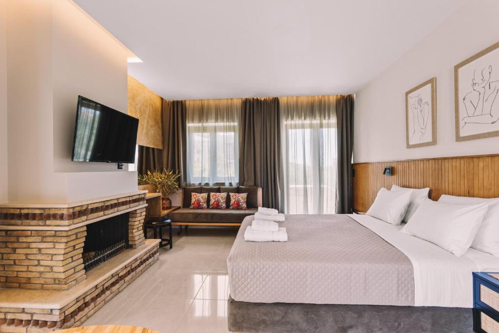 een hotelkamer met een groot bed en een open haard bij Bonos apartments in Stoupa
