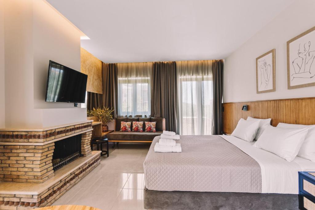 a hotel room with a large bed and a fireplace at Bonos apartments in Stoupa