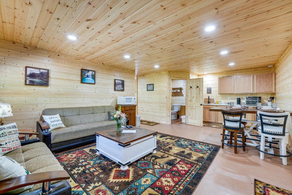 un soggiorno con divano e tavolo di Charming Cabin Near Roaring River State Park! a Cassville