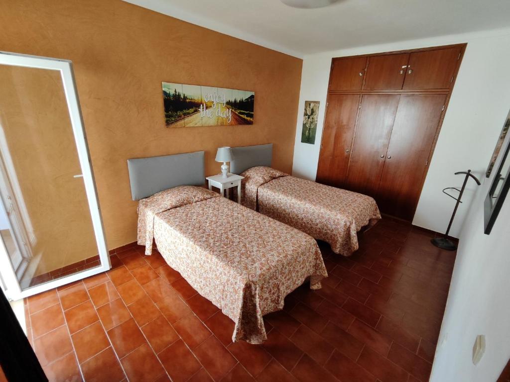 a hotel room with two beds and a mirror at Sol Nascente Apartment in Albufeira