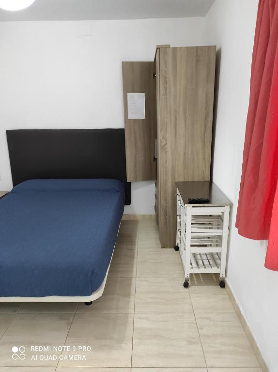 Cette petite chambre comprend un lit et une table de nuit. dans l'établissement Alojamiento Playa Centro Corralejo 16, à Corralejo