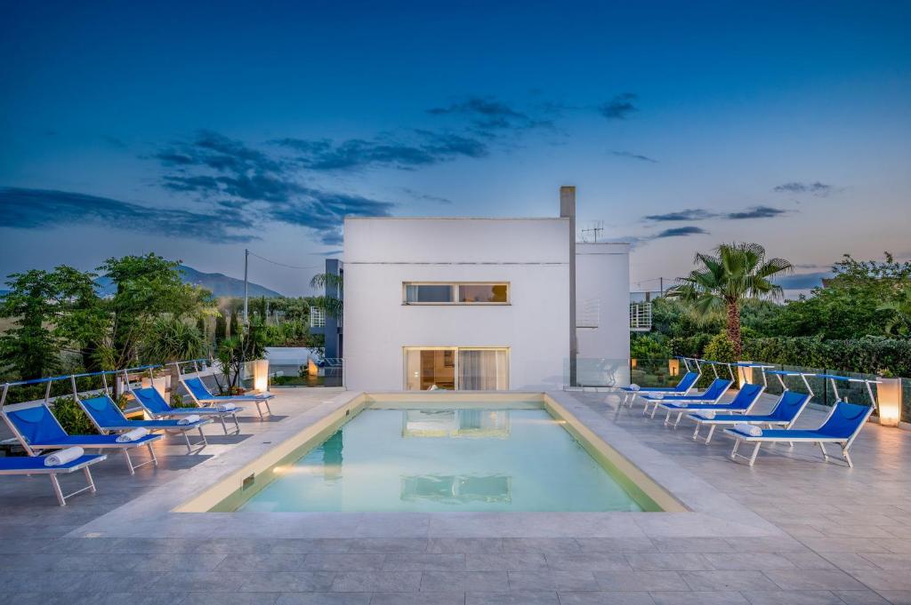 - une piscine avec des chaises et une maison dans l'établissement Villa Sikelia, à Alcamo