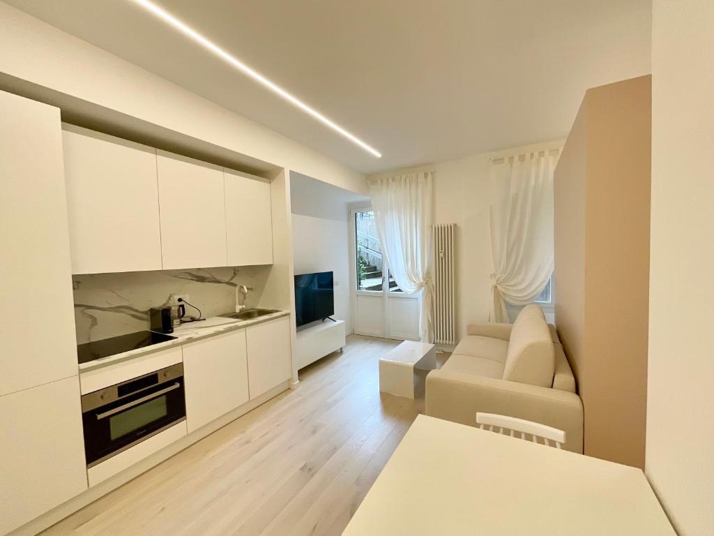 a white living room with a couch and a television at Apartment Suite - Charlize - in the heart of Milan in Milan