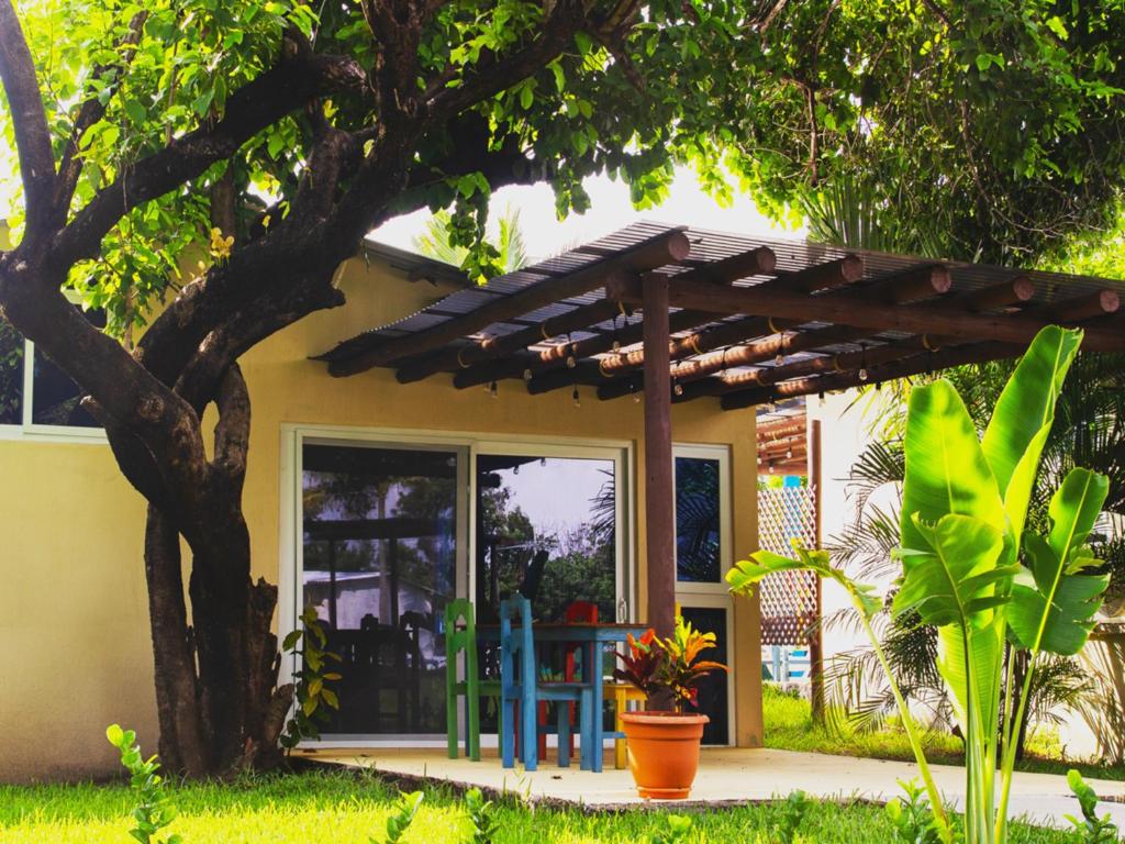 a house with a wooden pergola in the yard at El Arrecife Martin Pescador in Taxisco