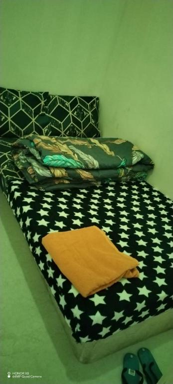 a bed with a black and white comforter on it at Matinxs Home in Abu Dhabi