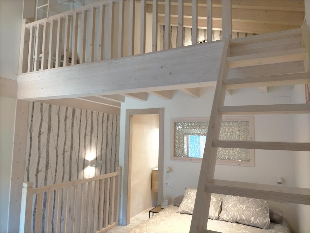 ein Hochbett in einem Schlafzimmer mit einer Treppe in der Unterkunft Picos de Europa Chic & Cool Apartments in Puertas