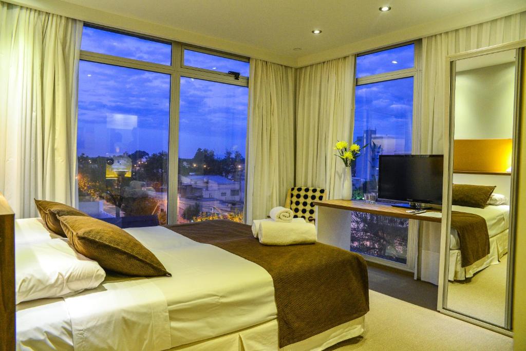 サンタフェにあるAmbit Boulevard Hotel Boutiqueの大きなベッドと大きな窓が備わるホテルルームです。