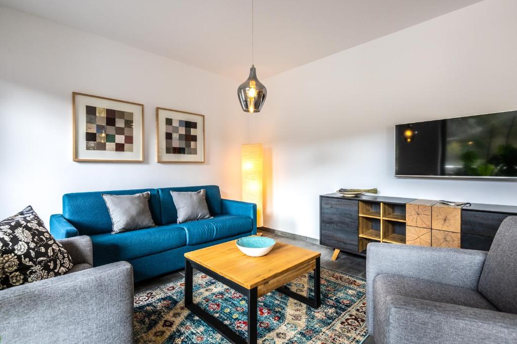 a living room with a blue couch and a table at Ferienwohnungen Assenmacher mit Sauna in Altenahr