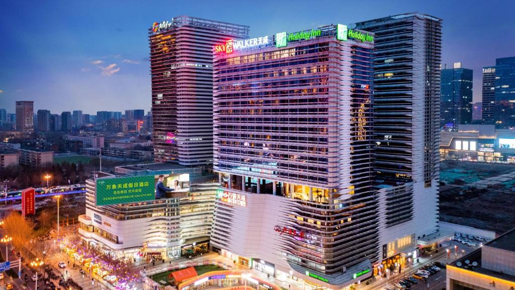 um edifício alto com um sinal em cima em Holiday Inn Shijiazhuang Central, an IHG Hotel em Shijiazhuang