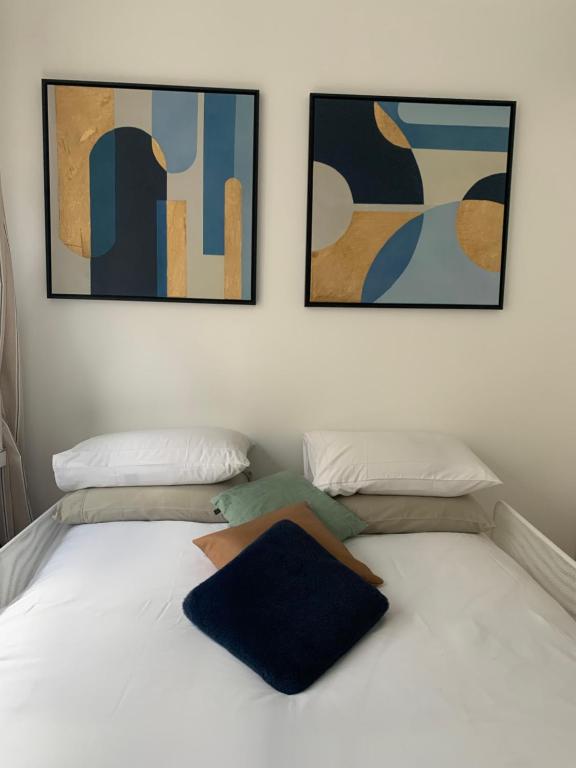 ブローニュ・ビヤンクールにあるNice stay in city center with Parkingのベッドルーム1室(壁に2枚の写真が飾られたベッド1台付)
