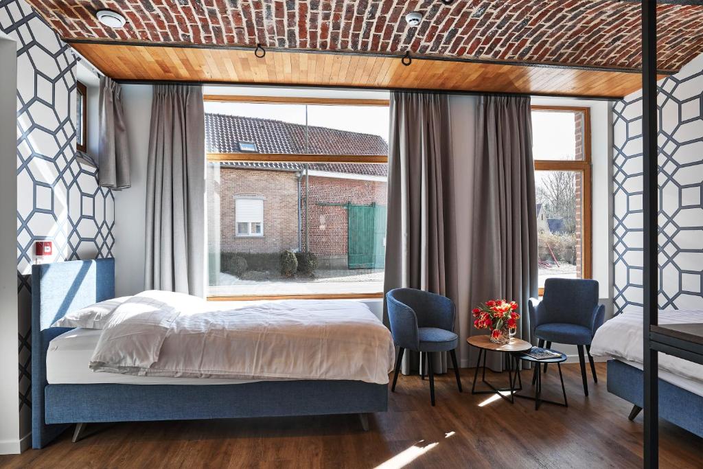 a bedroom with a bed and a large window at Kamerrijk in Pepingen