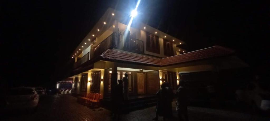 a building with a light on top of it at night at The Village Courtyard- Organic farm & homestay in Pīrmed