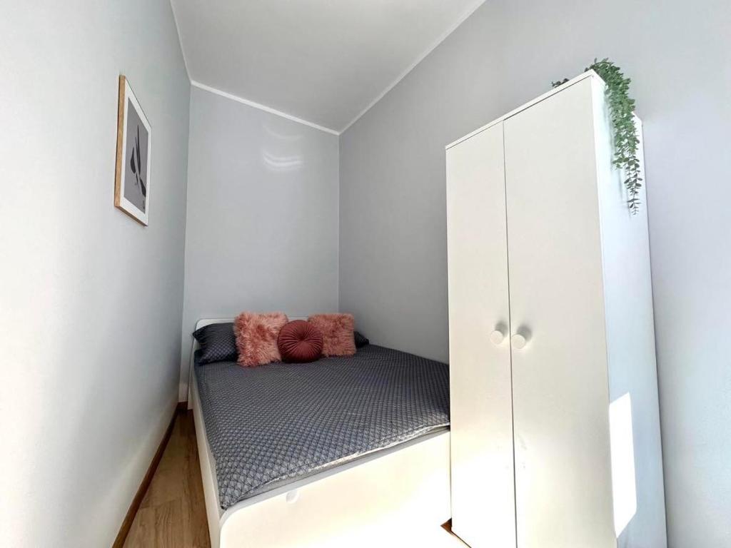 um pequeno quarto com uma cama e um espelho em MMRent Shadow Room em Gdansk