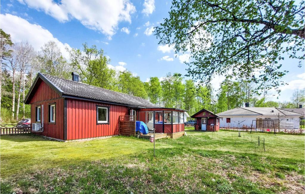 ein rotes Haus mit einem Spielplatz im Hof in der Unterkunft Amazing Home In Ljungby With Harbor View in Ljungby