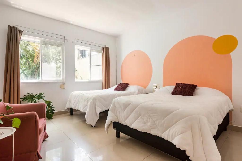 1 dormitorio con 2 camas y sofá en Beautiful Apartment surrounded by nature w/Pool, en Cancún