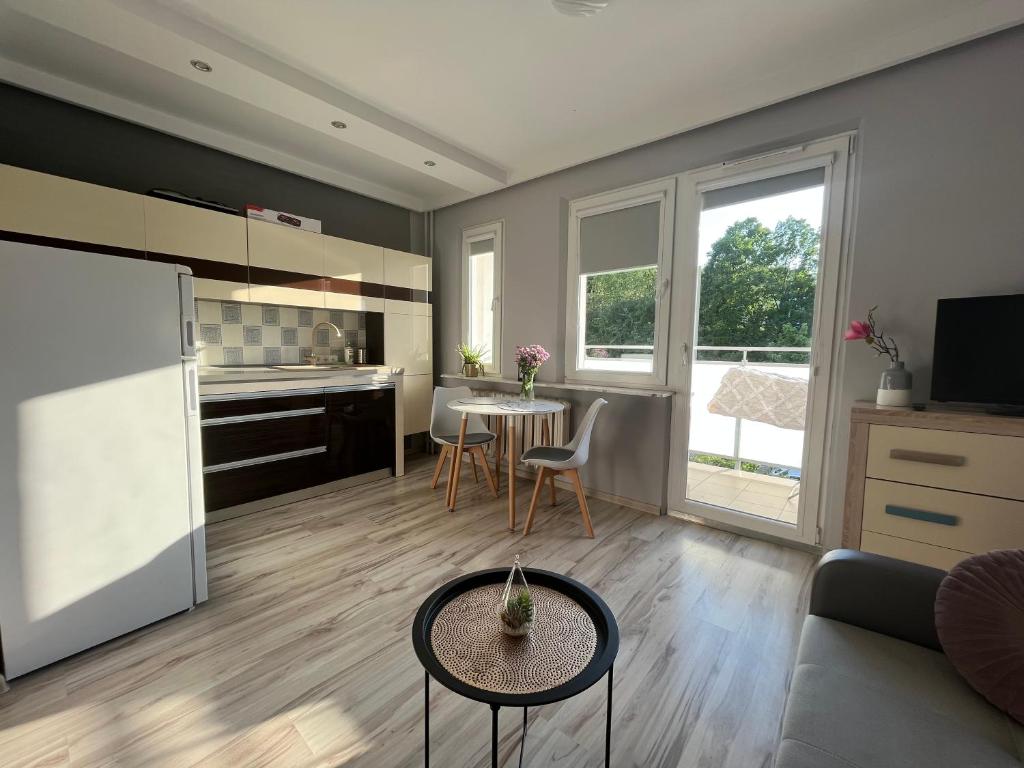 uma cozinha e sala de estar com mesa e cadeiras em Apartament blisko morza em Gdynia