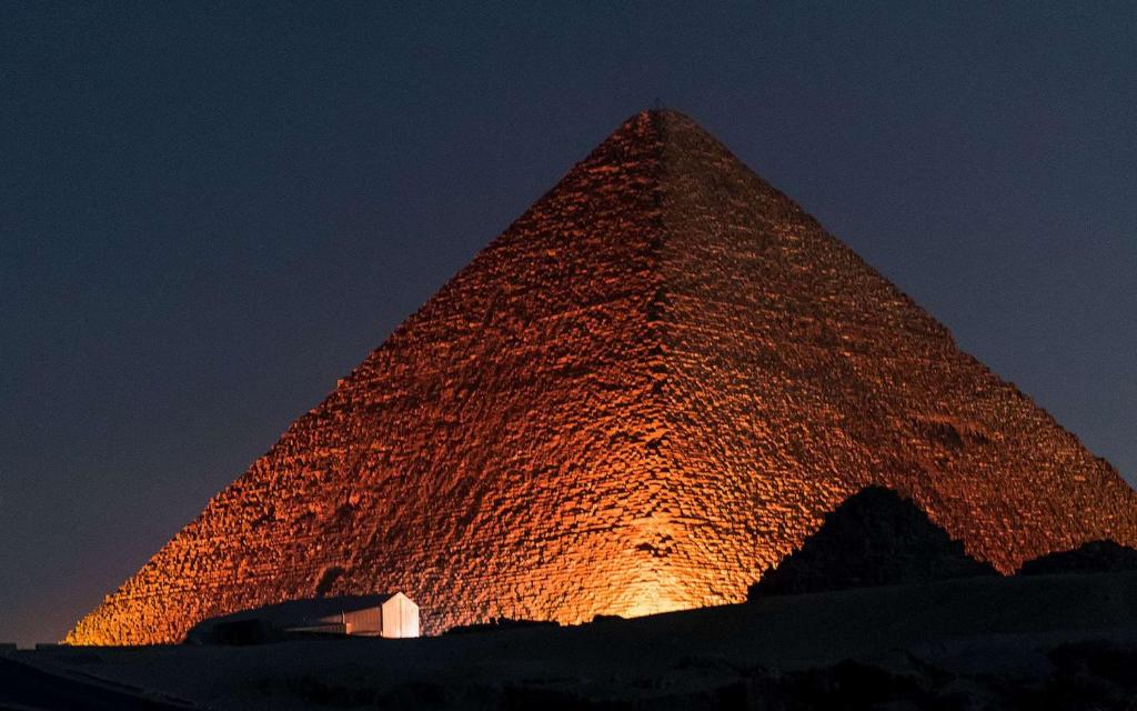 a pyramid is lit up at night at APPARTEMENTS HOTEL PYRAMIDES in Taza