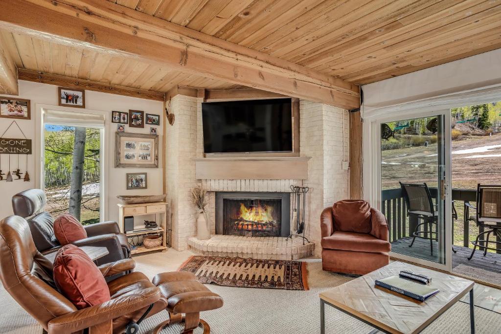 a living room with a fireplace and a tv at Interlude Condominiums 2-Bedroom Unit 209 in Snowmass Village