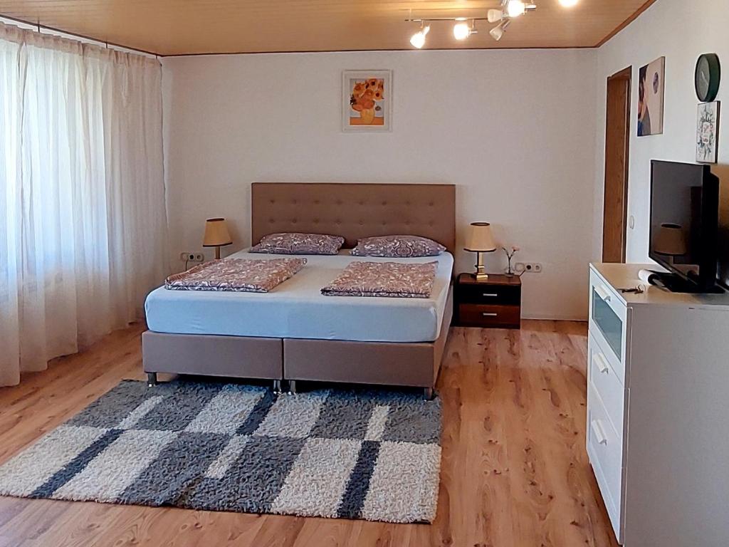 a bedroom with a bed and a flat screen tv at Private Studio Apartment with Balcony in Dortmund-Brackel in Dortmund