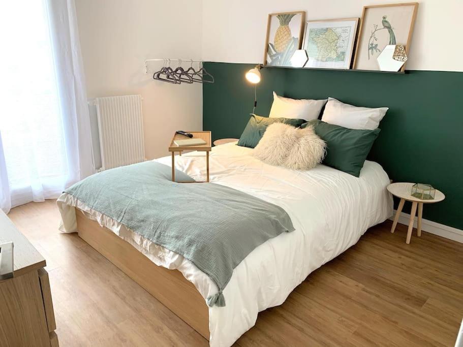 une chambre avec un grand lit avec un mur végétal dans l'établissement Le Minimes : vue de rêve au coeur de Toulouse, à Toulouse