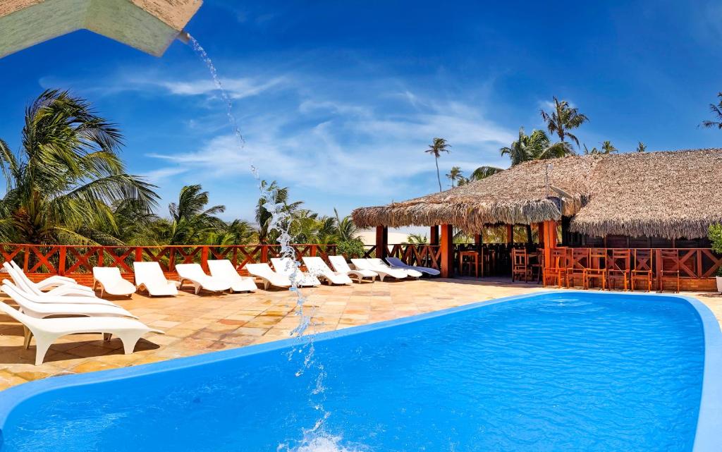 a resort with a swimming pool and lounge chairs at Pousada do Norte in Jericoacoara