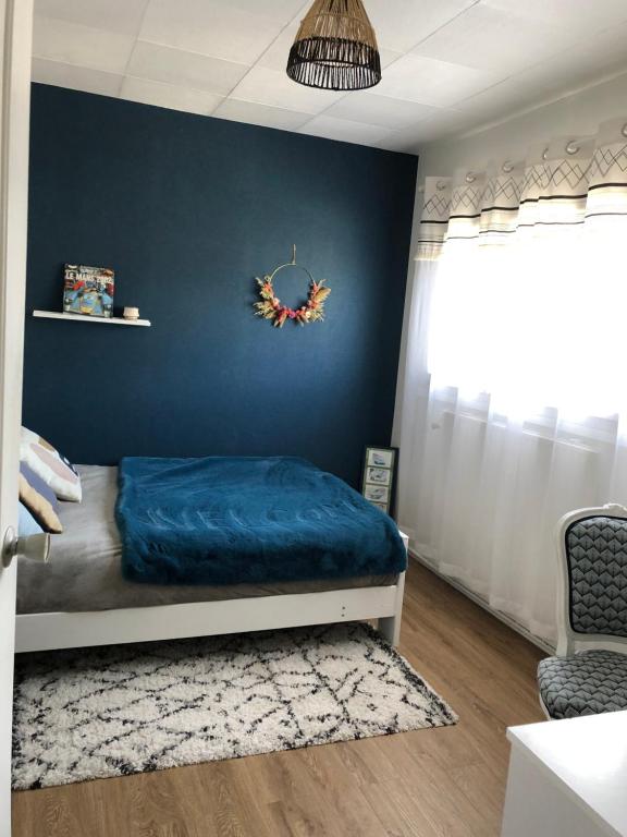 una camera con un letto con una parete blu di Chambre d hôte spéciale évènements sur circuit 24h du Mans a Mulsanne