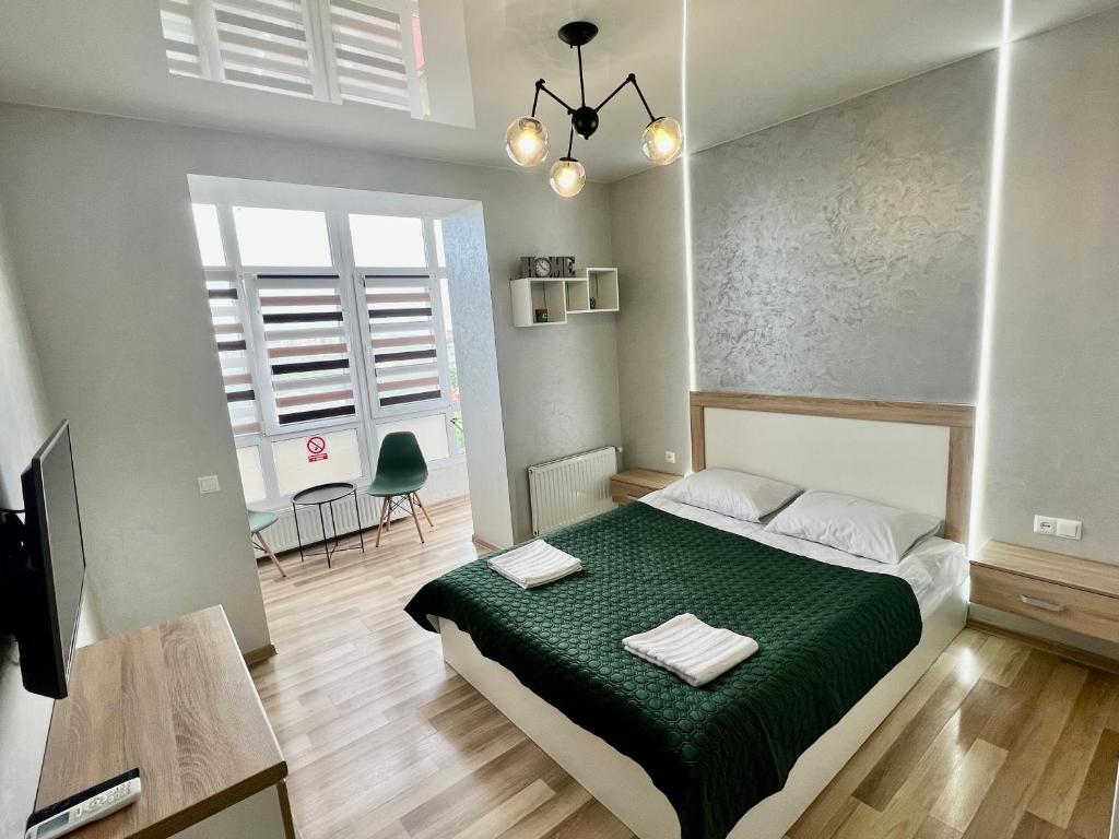 ein Schlafzimmer mit einem Bett mit einer grünen Bettdecke in der Unterkunft Apartment for you in Iwano-Frankiwsk