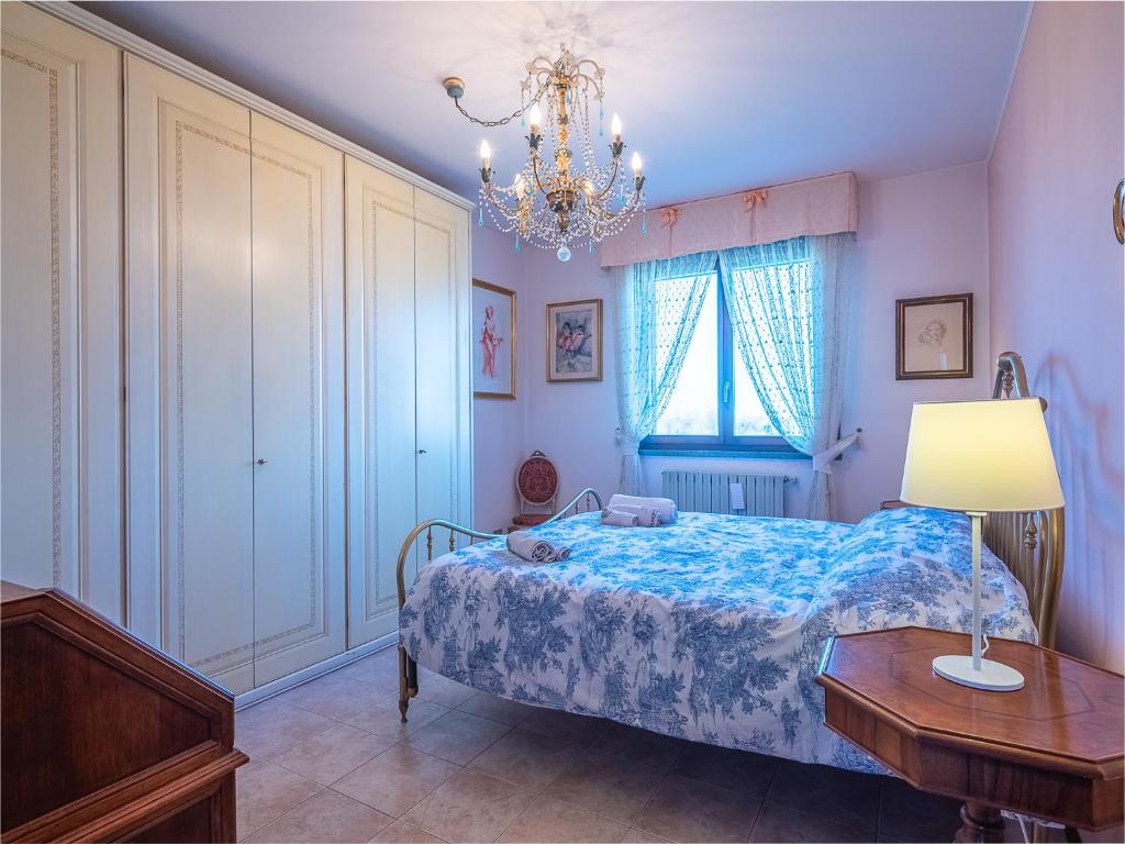 um quarto com uma cama, uma mesa e um lustre em Il Bosco di RE guesthouse, camera matrimoniale em Reggio Emilia