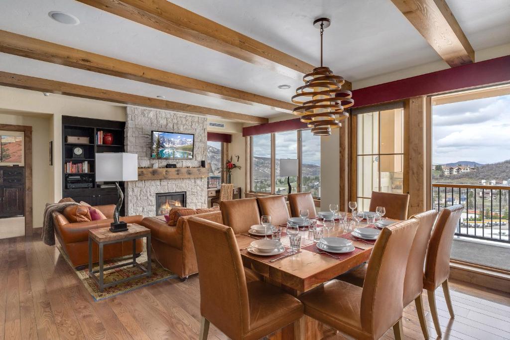 a dining room with a table and a fireplace at Edgemont 2601 - Luxury Ski-in Ski-out Condo in Steamboat Springs