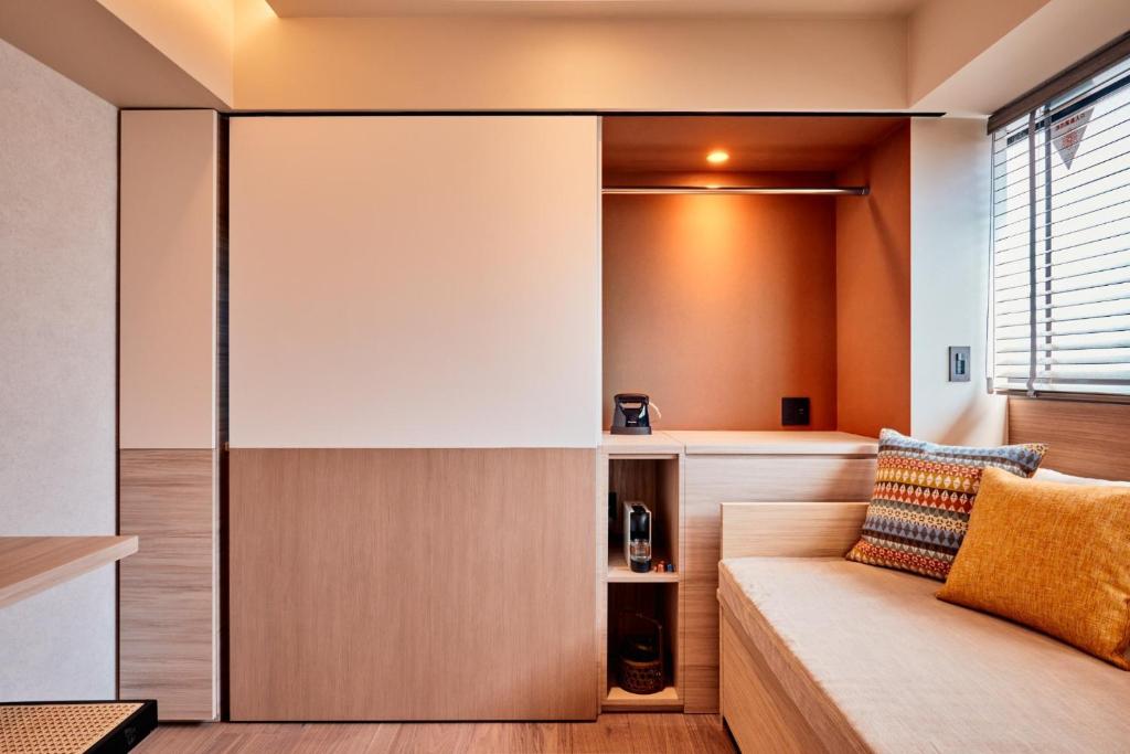 uma sala de estar com um sofá e uma janela em LiveGRACE Mabuji Park Hotel - Vacation STAY 51965v em Tóquio