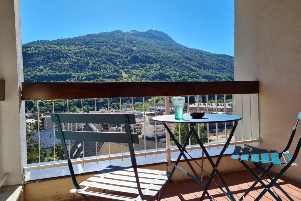 a table and chairs on a balcony with a view of a mountain at Apartment with view of Prorel in Briançon
