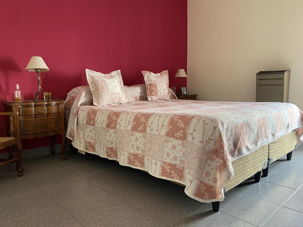1 dormitorio con 1 cama con pared roja en Tradicional casa en Miramar Hola Sur en Miramar