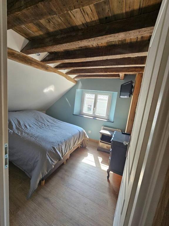 a bedroom with a bed and a window at Ma p'tite cabane in Neufmarché