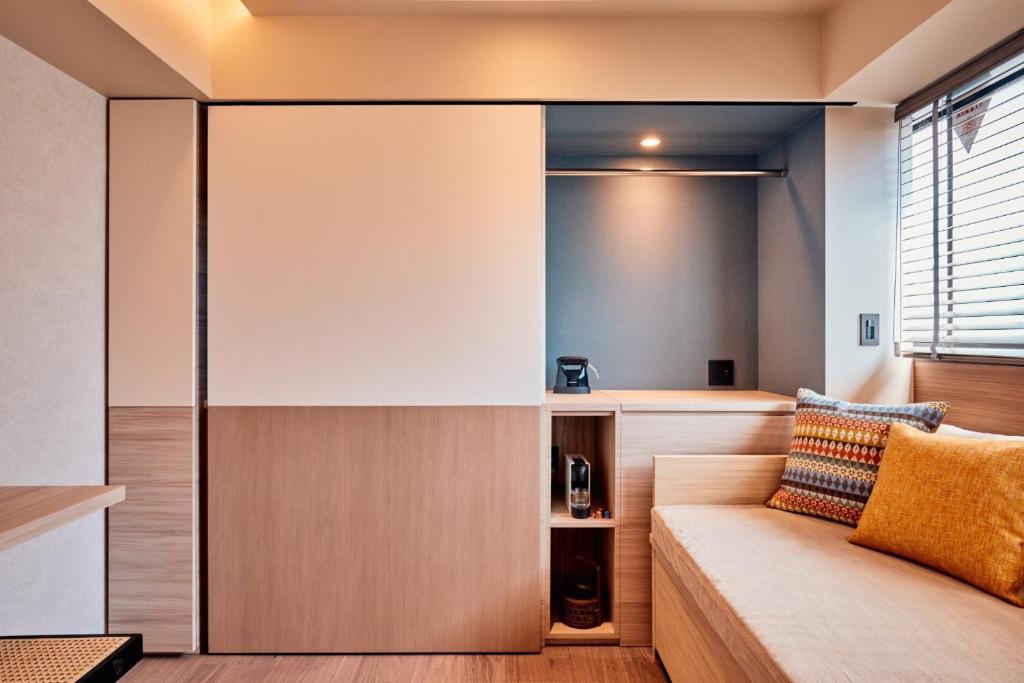 ein Wohnzimmer mit einem Sofa und einem Fenster in der Unterkunft LiveGRACE Mabuji Park Hotel - Vacation STAY 51943v in Tokio