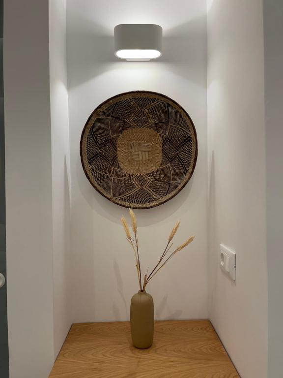 a vase on a table with a plate on a wall at Galatia Villas in Fira