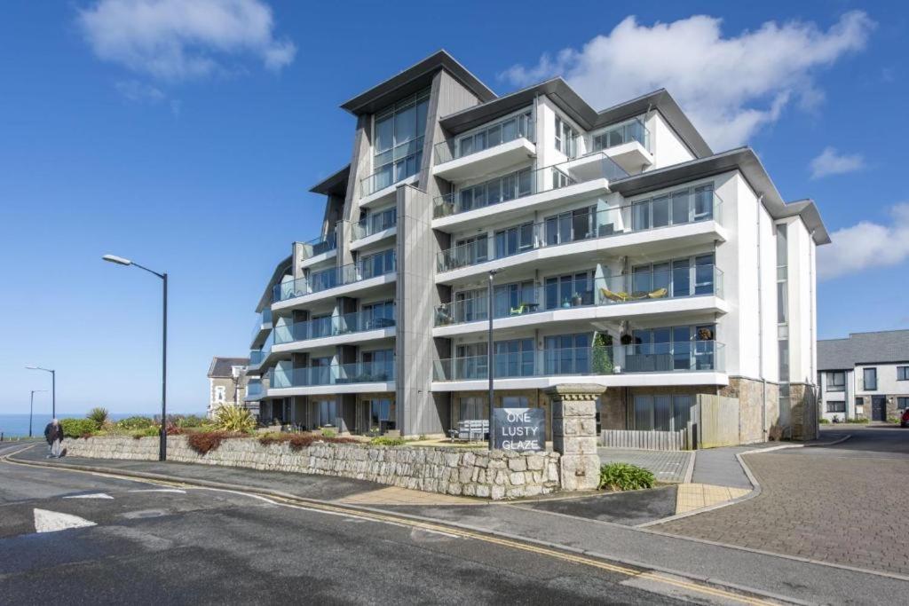 a large white building on the side of a street at Sea View Apartment at One Lusty Glaze in Newquay