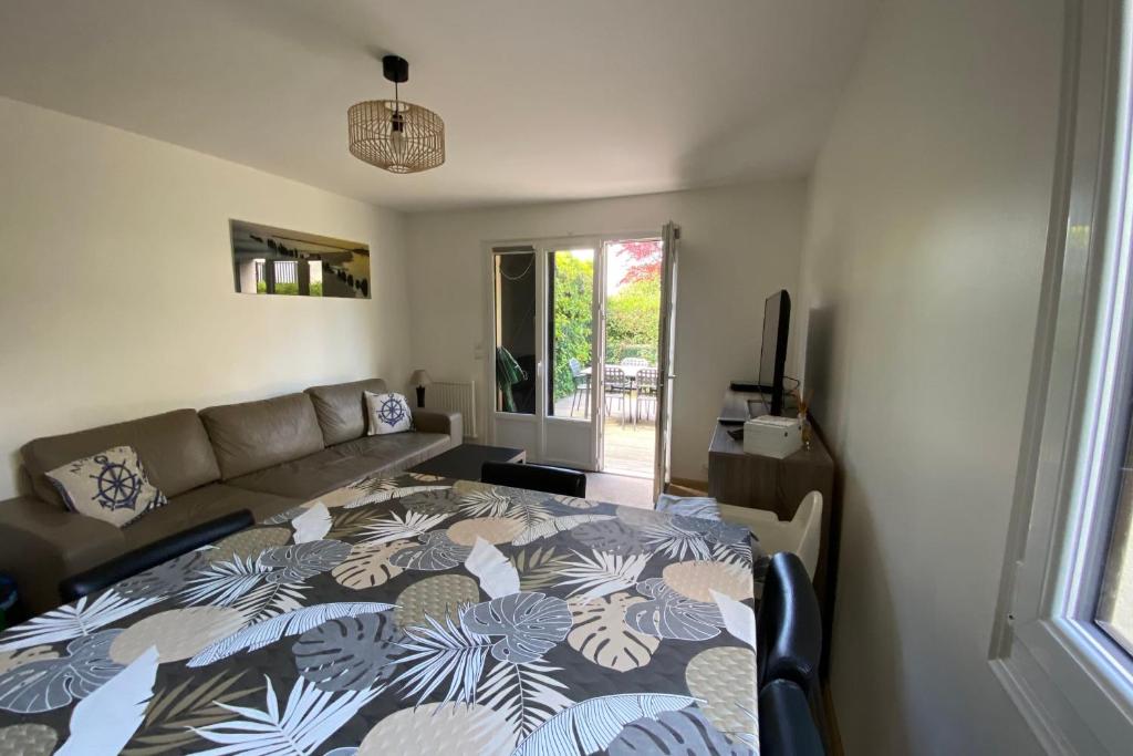un salon avec un lit et un canapé dans l'établissement Bright cocoon with garden near the sea, à Cabourg