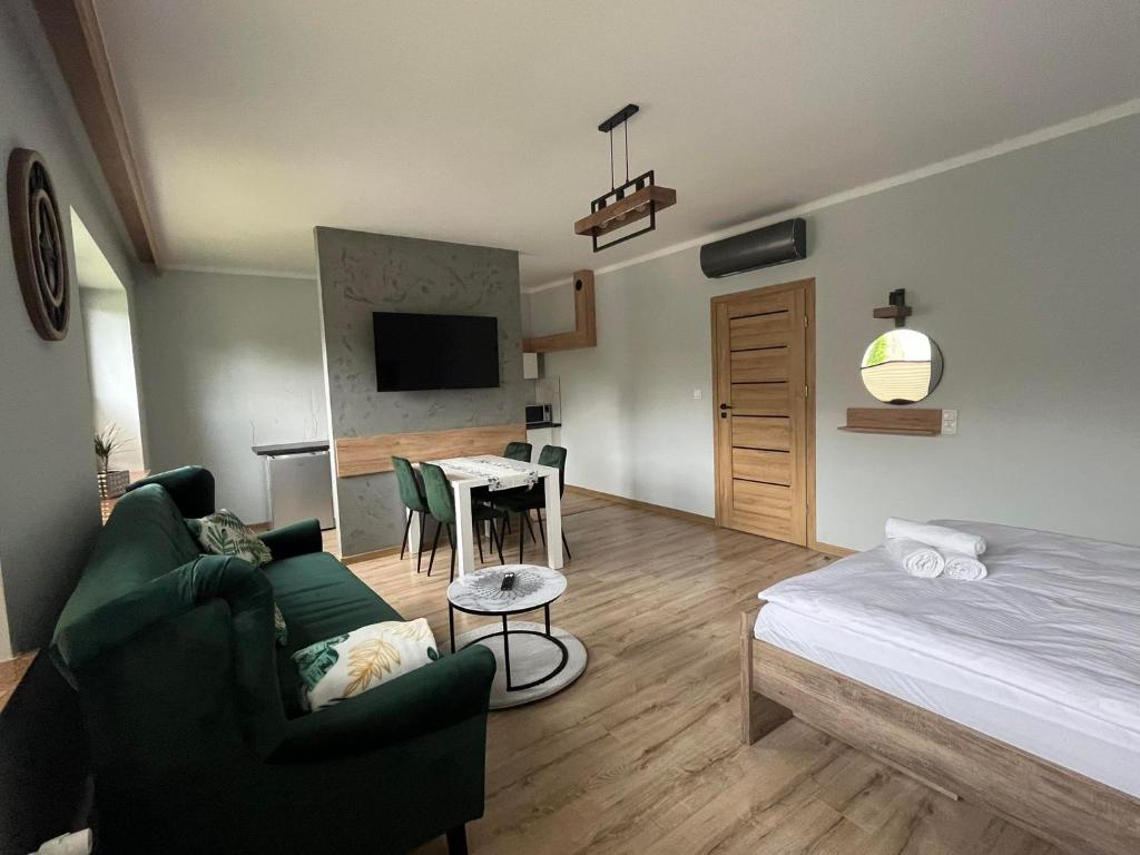 ein Wohnzimmer mit einem Bett und einem Tisch mit Stühlen in der Unterkunft Apartamenty Wadowity- Energylandia Zator in Wadowice