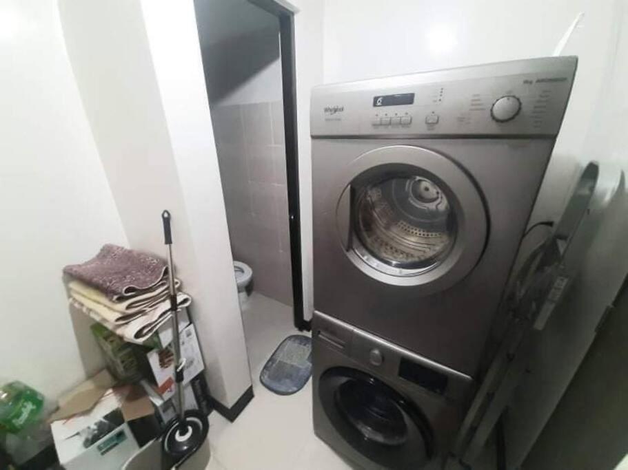 uma máquina de lavar roupa na casa de banho com um espelho em Cubao Manhattan HEights Unit 6H Tower B, 2BR em Manila