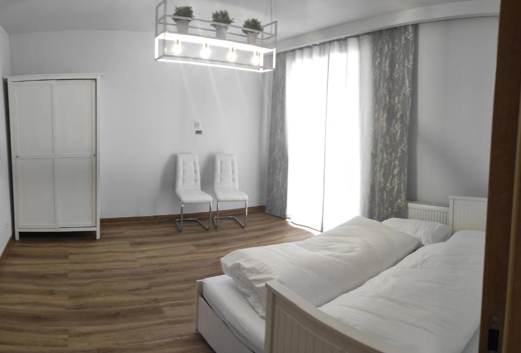 - une chambre blanche avec un lit et une fenêtre dans l'établissement Apartament Olchowa Prestige 3, à Ustroń