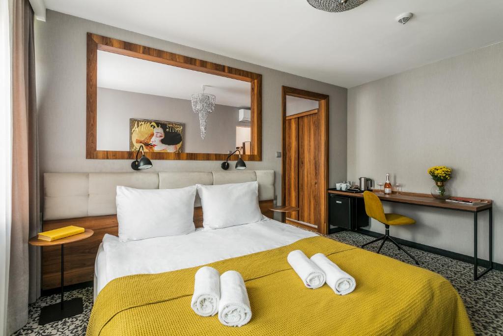 sypialnia z dużym łóżkiem i żółtym kocem w obiekcie No.23 Premium Aparthotel w Krakowie