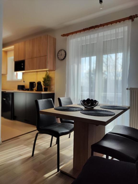a kitchen and living room with a table and chairs at Kinizsi Apartman in Miskolc